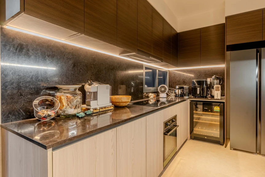 Contemporary kitchen with wood-grain cabinet design and sleek black marble countertops.